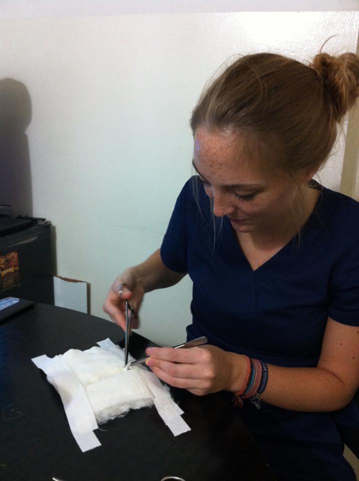 En nuestra pasantía para estudiantes de medicina los pasantes ayudan a preparar material. Durante su pasantía de Medicina en Argentina, una pasante ayuda a cortar bandas.